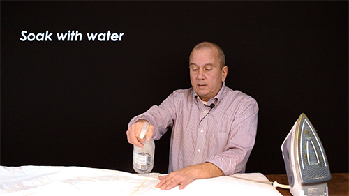 First spray your bed sheets with water until they are wet.
